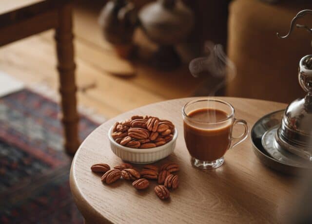 a bowl of pecans and a cup of coffee on a table