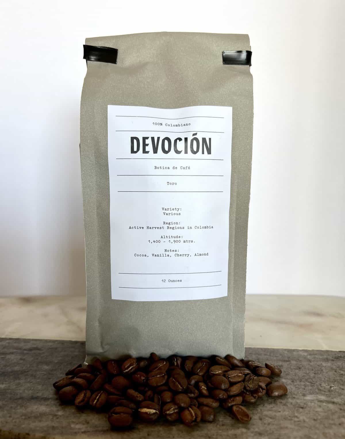 Devocion Botica de Cafe Toro Coffee packaging stands on coffee beans scaled 1