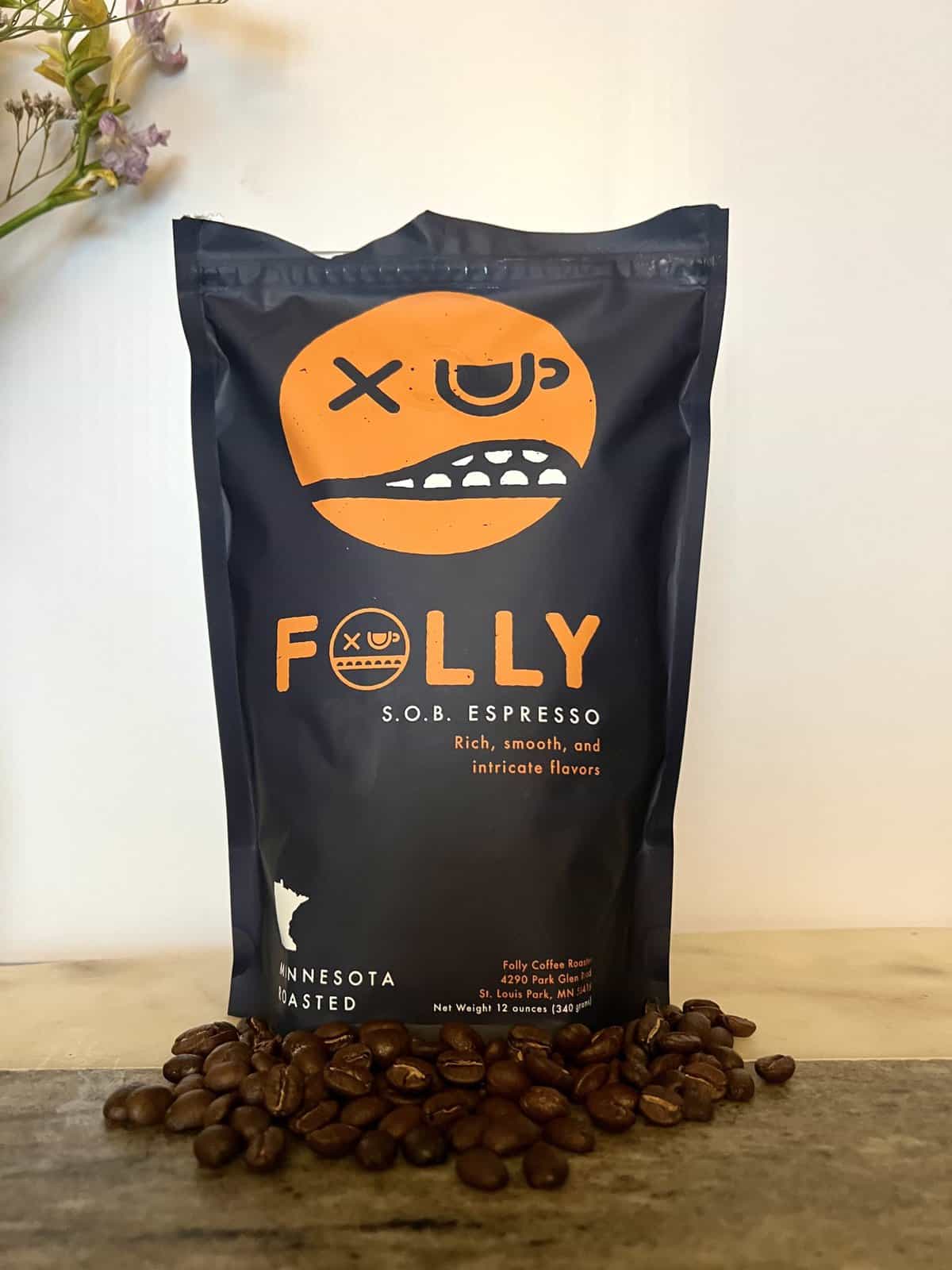 Folly Coffee Subscription Review: Quality Roasted Coffee 14 S.O.B. Espresso Folly coffee pack next to coffee beans
