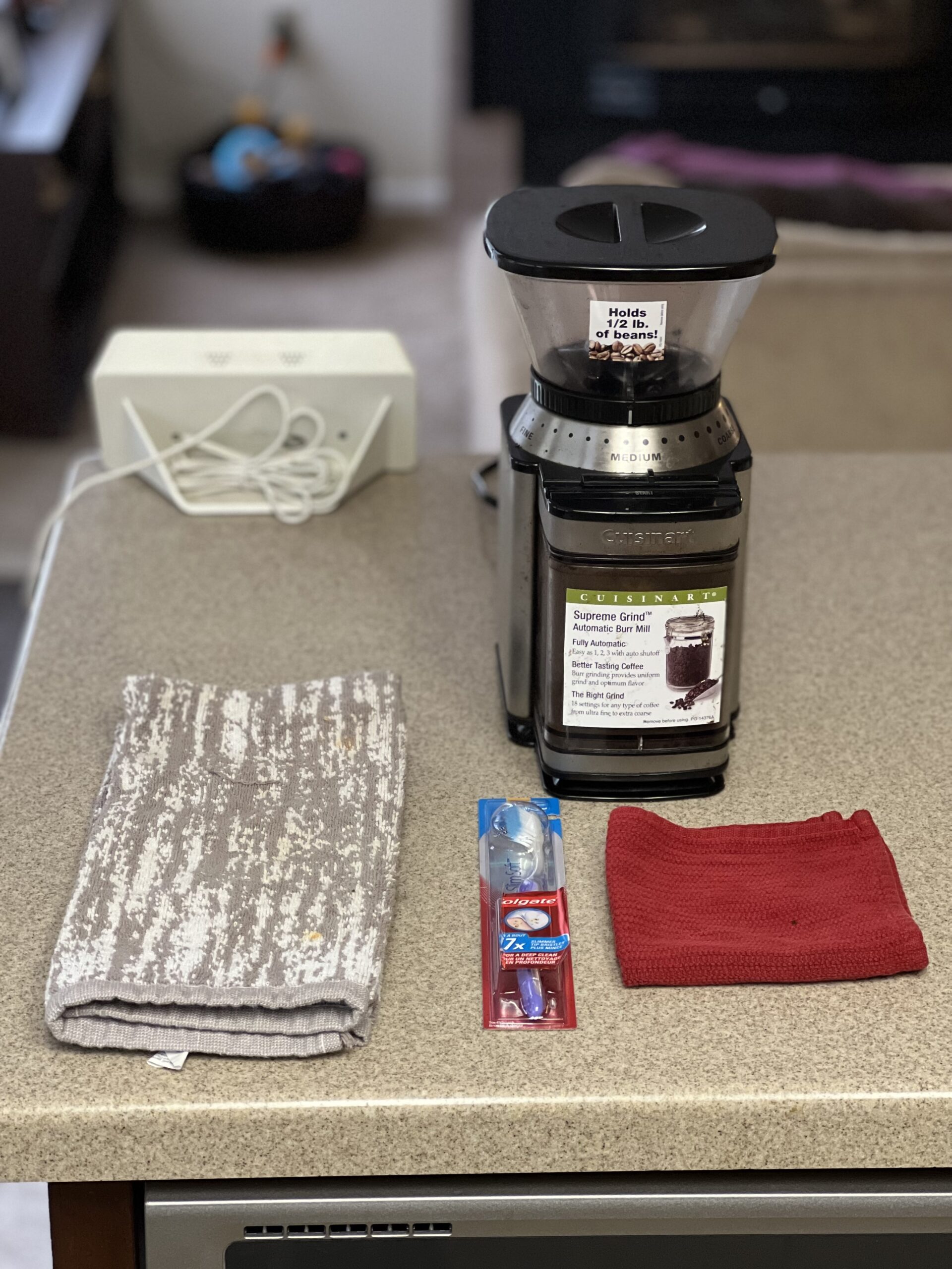 Cuisinart DBM-8 Coffee Grinder, two towels, and toothbrush on the table