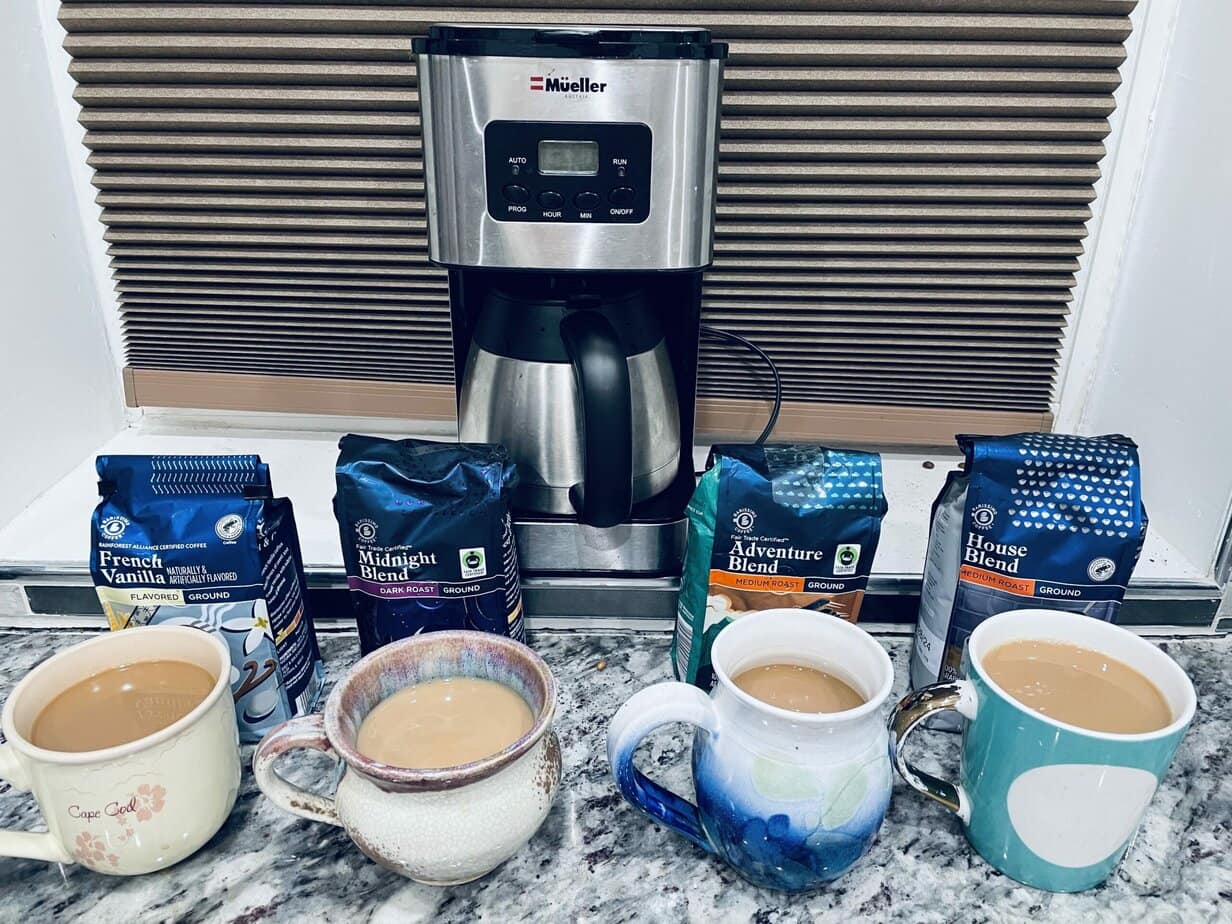 different Aldi coffee packs next to the cups of brewed coffee
