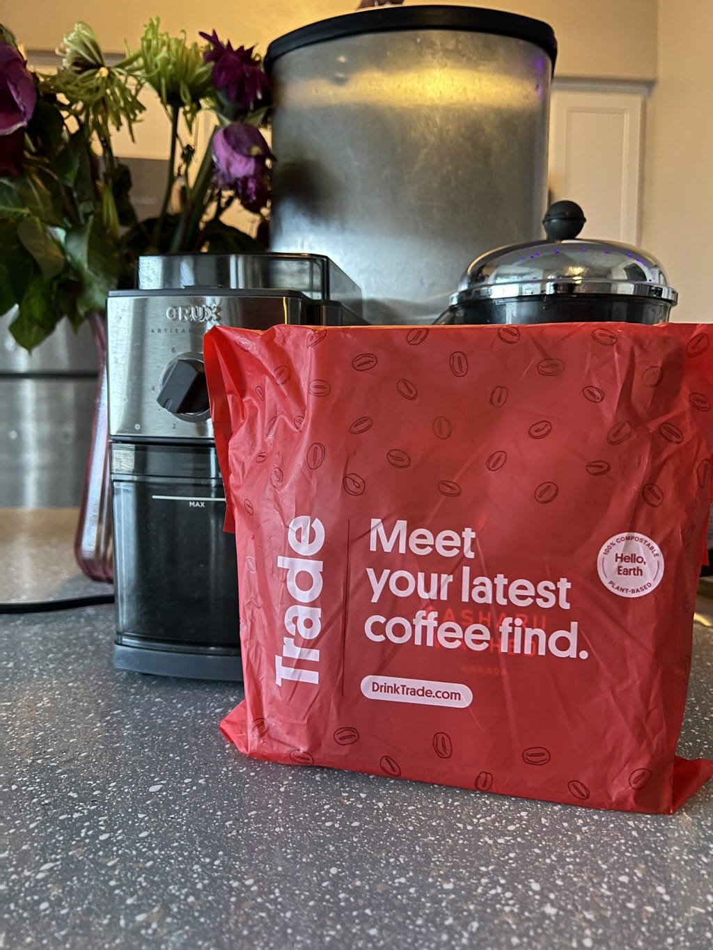 Madcap coffee in a red package against the background of a coffee grinder and a french press