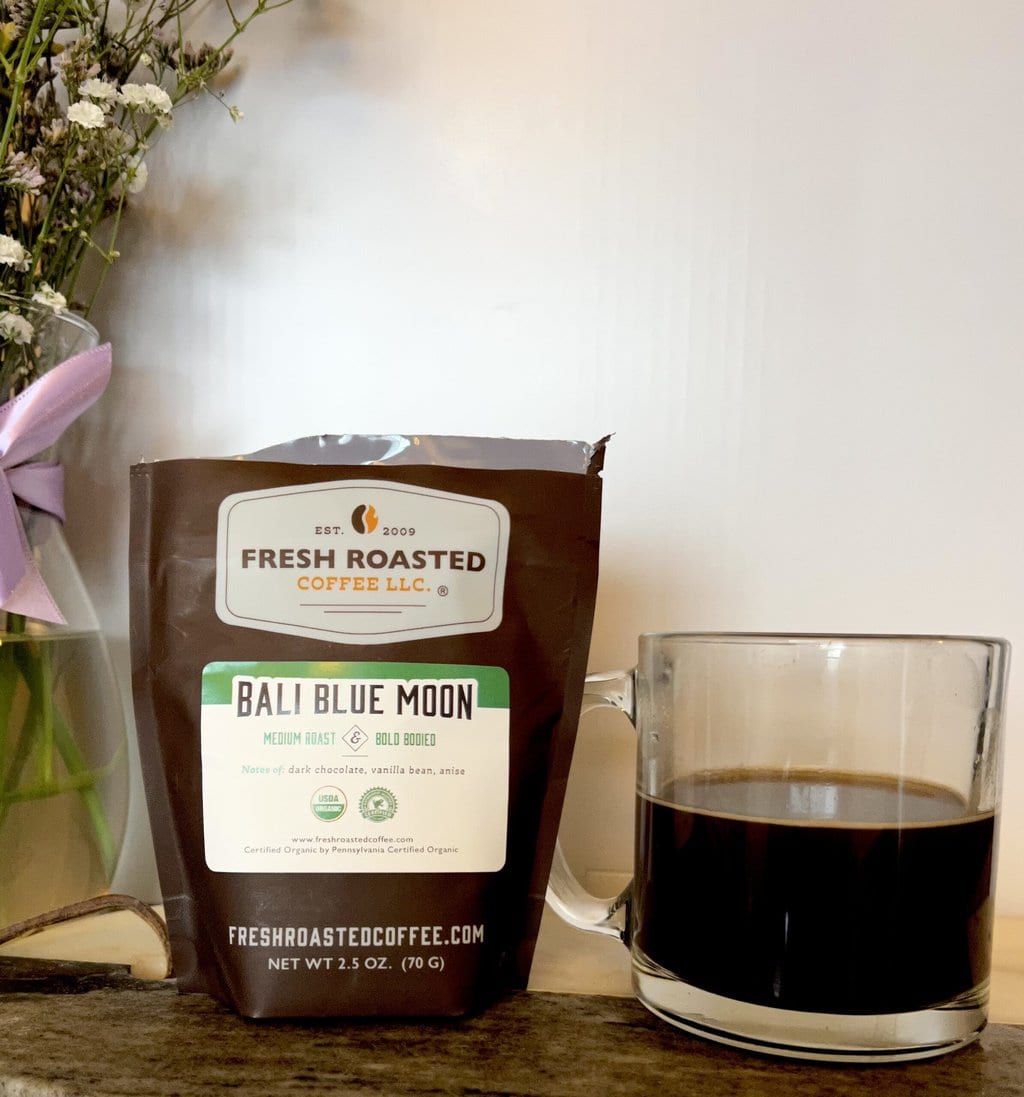 Fresh Roasted Coffee Subscription Review & Photos For 2024 23 Organic Bali Blue Moon next to a cup of coffee