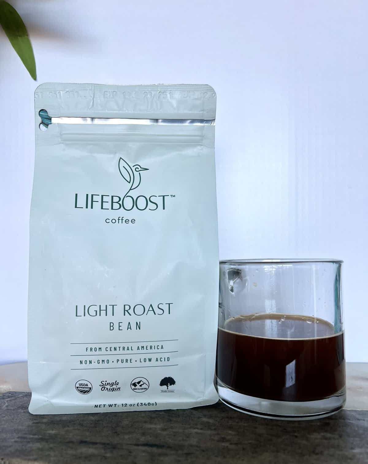 Lifeboost Coffee Brew & Review 9 an open package of Lifeboost Coffee Light Roast Whole Bean Coffee next to a cup of brewed coffee