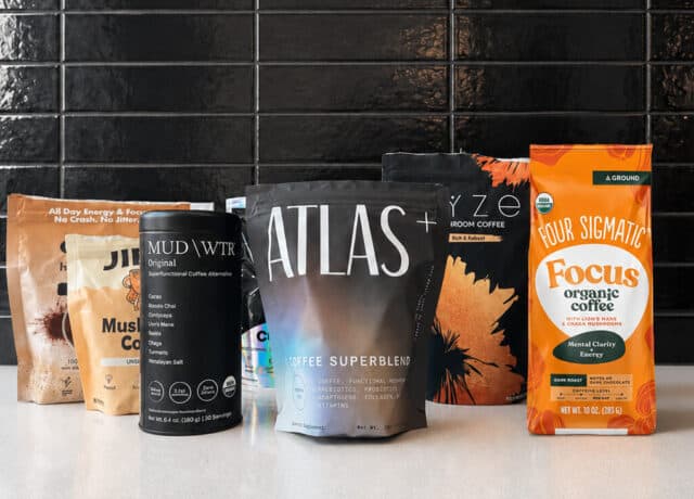 Five mushroom coffee brands lined up on a kitchen counter, including Atlas+ Superblend, RYZE, Four Sigmatic Focus and MUDWTR
