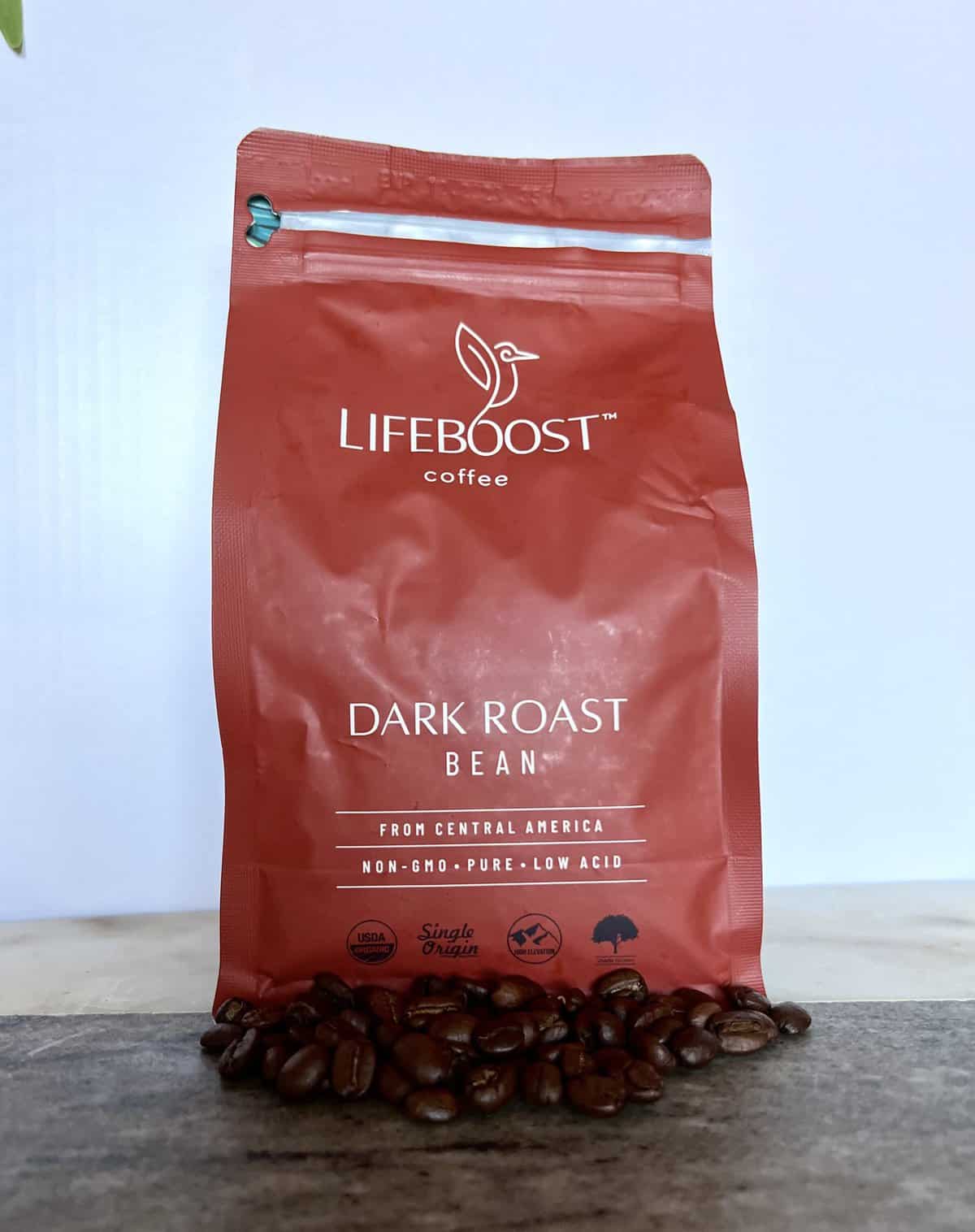 Lifeboost Coffee Brew & Review 15 open package of Lifeboost Coffee Dark Roast Ground Coffee next to the coffee beans
