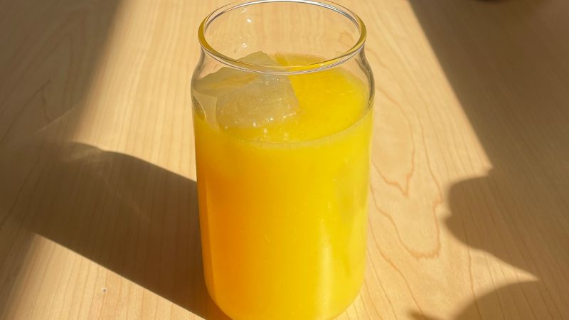pouring the orange juice over ice